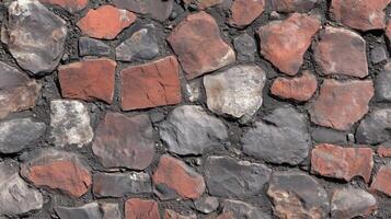 A brick wall with a variety of different colored bricks. The wall is made up of many different sized bricks, and the colors vary from red to gray. photo