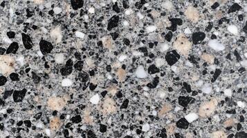 A black and white photo of a rocky surface with a few white specks.