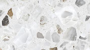 A white and grey stone wall with a few small rocks. The wall is made of stone and has a rough texture. photo