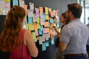 Marketing team brainstorming using sticky notes on wall photo