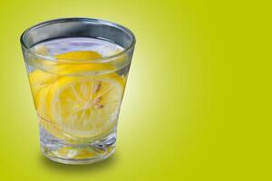 glass of water with lemon. water infused on yellow background, suitable for drink campaign background photo
