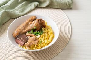 Egg noodles served dry with braised duck photo
