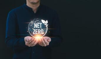 Businessman holding net zero icon with globe outline background for Net zero and carbon neutral concept. Net zero greenhouse gas emissions target. Climate neutral long term strategy. photo