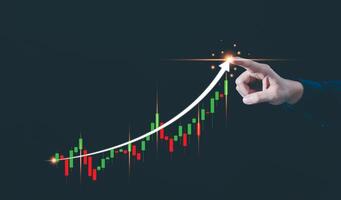 Close up of index finger pointing at peak of candlesticks chart on black background. Growth of stock market finance graph and digital trading concept and Investment risk management concept. photo