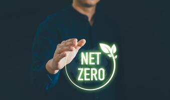 Businessman holding net zero icon with globe outline background for Net zero and carbon neutral concept. Net zero greenhouse gas emissions target. Climate neutral long term strategy. photo
