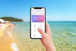 Controlling fridge and kitchen appliances from the beach with vacation mode activated. Mobile app in hand, enjoy smart home convenience while relaxing by the sea photo