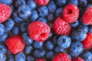 Fresh berry background. Texture of mixture raspberry and blueberry berries close up photo
