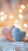 Two fabric hearts resting on a glittery surface with glowing heart bokeh and warm fairy lights illuminating the background, soft pastel colors photo