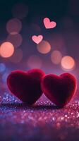 Two red velvet hearts on a glowing glitter surface, heart-shaped bokeh softly floating above, warm romantic tones of pink and purple photo