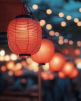 Bright red lanterns hanging in a festive display, glowing softly, with blurred street festivities in the background. photo