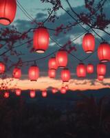 A display of red lanterns glowing at sunset, suspended in the air, creating a serene and festive scene. photo