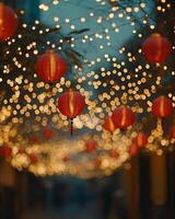 Traditional red lanterns softly glowing, strung along a street during a night festival, with blurred golden lights creating a festive feel photo