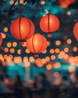 Vibrant red lanterns swaying gently, surrounded by blurry lights and a festive crowd in the background, glowing softly under warm lighting photo