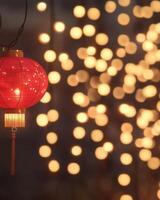 A string of glowing red Chinese lanterns with blurred golden lights in the background, creating a festive and elegant ambiance. photo