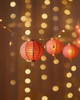 A string of glowing red Chinese lanterns with blurred golden lights in the background, creating a festive and elegant ambiance. photo