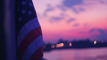 Partial view of the American flag under a pink and purple sunset, sky blurred in the background photo