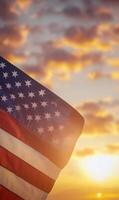 Vertical shot of the American flag, stars in focus with sunset-lit clouds in the background photo