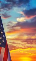 Vertical view of the American flag with fabric texture, colorful sunset sky in the background photo