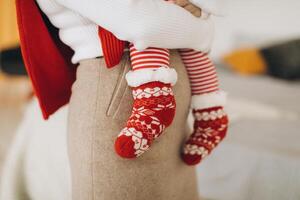 Fragment of mother and child in traditional Christmas clothes photo