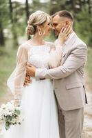 A bride and groom walk hand in hand through a pine forest, sunlight filtering through the trees, highlighting their joyful expressions. photo