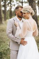 Wedding couple bride and groom walk hand in hand through a pine forest, sunlight filtering through the trees, highlighting their joyful expressions. photo