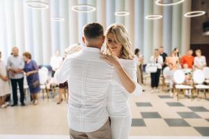 Elegant Couple Embracing at a Wedding Ceremony with Guests in Background photo