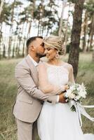 A bride and groom walk hand in hand through a pine forest, sunlight filtering through the trees, highlighting their joyful expressions. photo