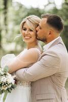 A bride and groom walk hand in hand through a pine forest, sunlight filtering through the trees, highlighting their joyful expressions. photo