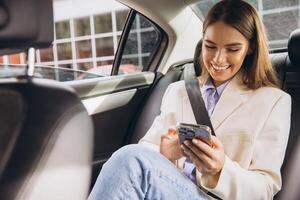 Smiling Woman Using Smartphone While Traveling in Car photo