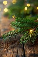 Close-up of a pine branch on a rustic wooden surface with bokeh lights photo