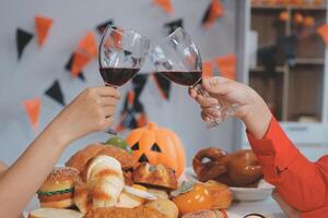 friendship, holiday and people concept - group of happy smiling friends in halloween costumes of vampire, devil, witch and cheetah at home party photo
