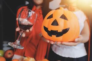 friendship, holiday and people concept - group of happy smiling friends in halloween costumes of vampire, devil, witch and cheetah at home party photo
