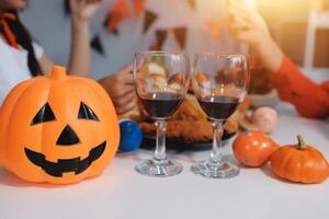 friendship, holiday and people concept - group of happy smiling friends in halloween costumes of vampire, devil, witch and cheetah at home party photo