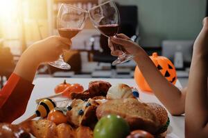 friendship, holiday and people concept - group of happy smiling friends in halloween costumes of vampire, devil, witch and cheetah at home party photo