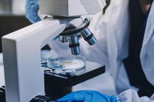 Scientist using microscope in laboratory. Close-up of a researcher's hands adjusting a modern microscope in a lab setting. Science concept photo
