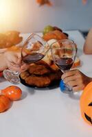 friendship, holiday and people concept - group of happy smiling friends in halloween costumes of vampire, devil, witch and cheetah at home party photo