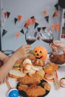 friendship, holiday and people concept - group of happy smiling friends in halloween costumes of vampire, devil, witch and cheetah at home party photo