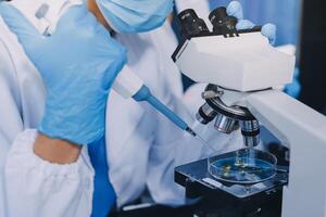 Scientist using microscope in laboratory. Close-up of a researcher's hands adjusting a modern microscope in a lab setting. Science concept photo