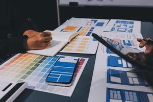 The designer team is designing the uxui system to make the uxui system work well on new phones and support system updates. Website development concept UI UX front end designer photo