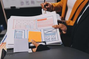 The designer team is designing the uxui system to make the uxui system work well on new phones and support system updates. Website development concept UI UX front end designer photo