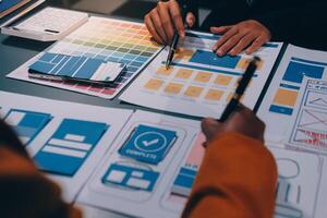 The designer team is designing the uxui system to make the uxui system work well on new phones and support system updates. Website development concept UI UX front end designer photo