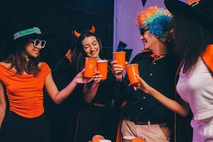 Joyful office Halloween party with coworkers in costumes, celebrating with drinks and laughter, fostering teamwork and festive spirit photo