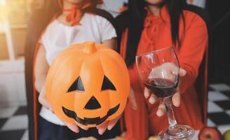 friendship, holiday and people concept - group of happy smiling friends in halloween costumes of vampire, devil, witch and cheetah at home party photo