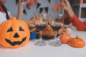 friendship, holiday and people concept - group of happy smiling friends in halloween costumes of vampire, devil, witch and cheetah at home party photo