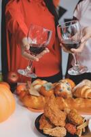 friendship, holiday and people concept - group of happy smiling friends in halloween costumes of vampire, devil, witch and cheetah at home party photo