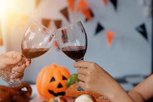 friendship, holiday and people concept - group of happy smiling friends in halloween costumes of vampire, devil, witch and cheetah at home party photo