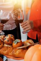 friendship, holiday and people concept - group of happy smiling friends in halloween costumes of vampire, devil, witch and cheetah at home party photo