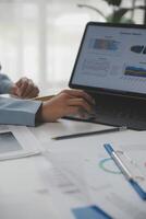 Close up of Business team analyzing income charts and graphs with modern laptop computer. Business analysis and strategy concept. photo