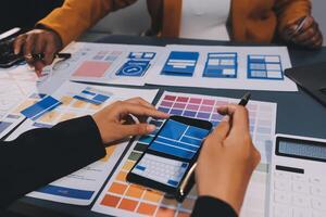 The designer team is designing the uxui system to make the uxui system work well on new phones and support system updates. Website development concept UI UX front end designer photo