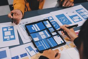 The designer team is designing the uxui system to make the uxui system work well on new phones and support system updates. Website development concept UI UX front end designer photo